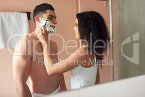 Let me try. Shot of a young woman shaving her boyfriends face in the bathroom.