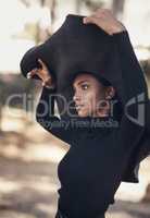 A womans hat should speak volumes. Shot of a fashionable young woman posing against a nature background.