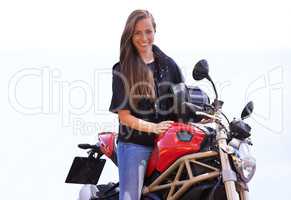 Shes a true biker chick. A beautiful young woman sitting on her red motorcycle.