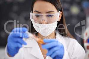 Finally the compound is complete. Shot of a female scientist observing a sample in a test tube.