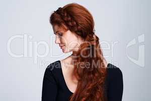 Fairytale beauty. Studio shot of a young woman with beautiful red hair posing against a gray background.