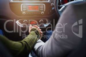 Life is a journey best travelled together. Closeup shot of a couple holding hands while driving in a car.