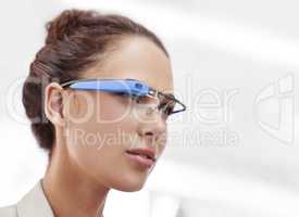 Cropped shot of an attractive young woman wearing glasses with internet access. The commercial product(s) or designs displayed in this image represent simulations of a real product, and are changed or altered enough so that they are free of any copyright 