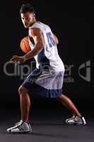 Defend defend defend. Studio shot of a basketball player against a black background.