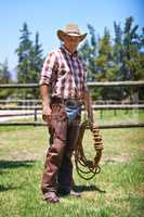 Time to rustle up some outlaws. A mature cowboy outdoors on his farm.