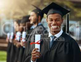 Imagine the doors this could open. Portrait of a young man holding his diploma while standing with his fellow students on graduation day.