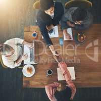 Networking is vital in the business world. High angle shot of businesspeople shaking hands during a meeting in an office.