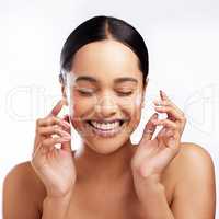 Soothe sensitive skin with an enriched moisturiser. Studio shot of a beautiful young woman applying moisturiser to her face against a white background.