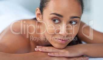 Relax and unwind. Shot of a beautiful young woman relaxing on a massage table at a spa.