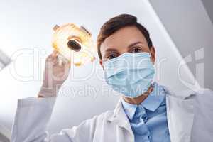 Open wide.... Low angle shot of a dentist getting ready to perform a procedure on a patient.