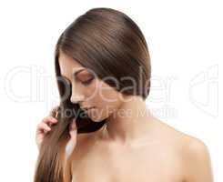 Appreciating her stunning hair. A beautiful young woman with luxurious hair isolated on a white background.