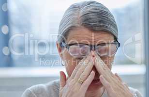 Wheres my pain meds. Shot of a mature businesswoman sitting alone in the office and suffering from a headache.