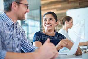 Working with brilliant minds. Beautiful professional woman looking positively at a male coworker in a bright meeting room.