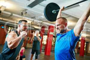 Be stronger than your excuses. Shot of a fitness instructor motivating his client during their workout session.