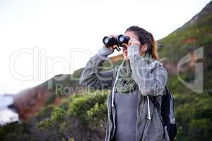 Wow The views amazing.... Shot of an attractive young woman using binoculars while out hiking.