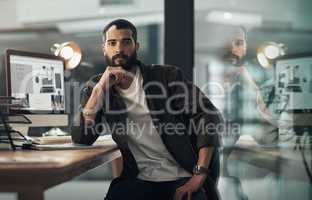 Late nights wont stop my mission. Portrait of a confident young businessman working late at night in a modern office.