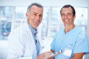 Doctor and resident smiling. Portrait of two men in the healthcare profession.