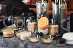 Tools of the beauty trade. Shot of a numerous amount of different types of makeup laid out on top of a table.