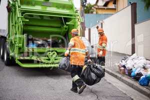 One street at a time.... Cropped shot of a garbage collection team at work.