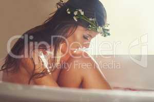 Pamper the skin youre in. Shot of a beautiful nude woman relaxing in a bathtub at home.