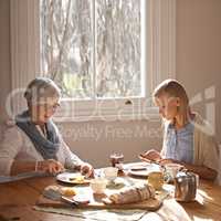 Theres nothing like grandmas homemade bread. Cropped shot of an attractive young woman visiting her gran for tea.