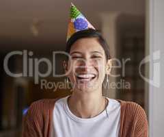 Hooray for my special day. Portrait of a cheerful young woman wearing a party hat at home.