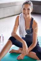 Taking a break to keep hydrated. A beautiful young woman taking a break from her yoga routine.