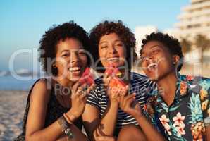 Sharing is caring Including our smiles. Portrait of three attractive young women eating watermelon pieces on the beach during the day.