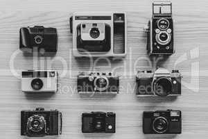 Vintage photo cameras on wooden background.