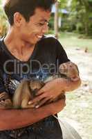Monkey keeper- Thailand. A Thai macaque being held by his keeper.
