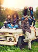 The best thing about memories is making them. Portrait of a group of friends posed around an old truck in a field.