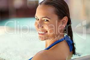You never regret a swim. Shot of a young woman relaxing in the pool at a spa.