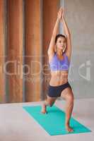 Poise and control. A beautiful young woman doing yoga at home.