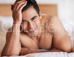 Man of the morning. Portrait of a happy young man lying in bed feeling well rested.