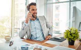 Thats just the news I was hoping to hear. Shot of a handsome young businessman talking on a cellphone in an office.