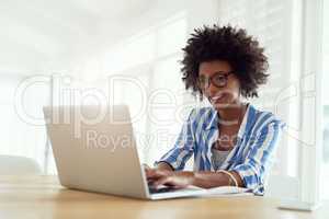 Self-employed and totally loving it. Cropped shot of a young woman working on her laptop at home.