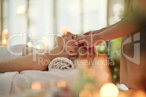 Restore balance to your whole body and mind. Cropped shot of a young woman enjoying a head massage at a spa.