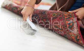 Some people forget this spot but not me. Cropped shot of an unrecognizable woman sweeping under the carpet at home.