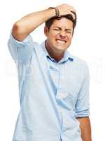 Suffering from self loathing. A handsome young man holding his head in pain against a white background.