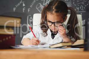 Shes the brightest little girl. Shot of an academically gifted young girl working in her classroom.
