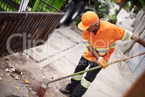 Ridding the streets of rubbish. Cropped shot of a garbage collection worker sweeping the sidewalk.