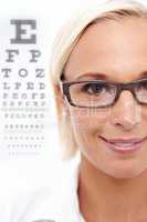Shes a sight for sore eyes. A cropped shot of a beautiful optometrist in front of a snellen chart.