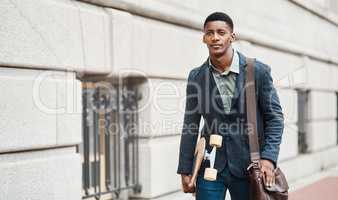 Someday isnt in the vocabulary of go getters. Shot of a young businessman holding a skateboard while walking through the city.