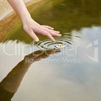 Creating water ripples. Cropped shot of a finger touching water to form ripples.