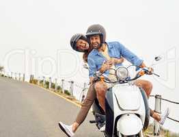 The lovebirds are hitting the road. Shot of an adventurous couple out for a ride on a motorbike.