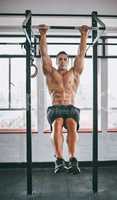 Aim high. Shot of a muscular man working out in a gym.