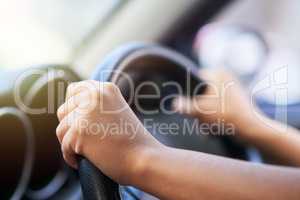 Enjoy the journey. Shot of hands holding onto a steering wheel while driving.