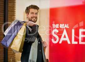On a bargain hunting mission. Portrait of a happy young man on a shopping spree.