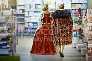 Leteths goeth to the next aisle dear. Rearview shot of a king and queen looking at goods while shopping in a modern grocery store.