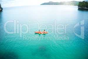 Were paddling away into paradise together. High angle shot of an adventurous young couple canoeing together in the beautiful oceans of Indonesia.